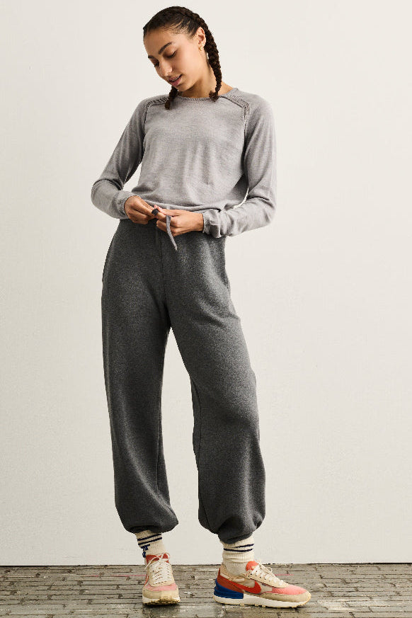 grey wool sweatpant with drawstrings and pockets shown with grey merino seamless sweater on woman with braids and sneakers